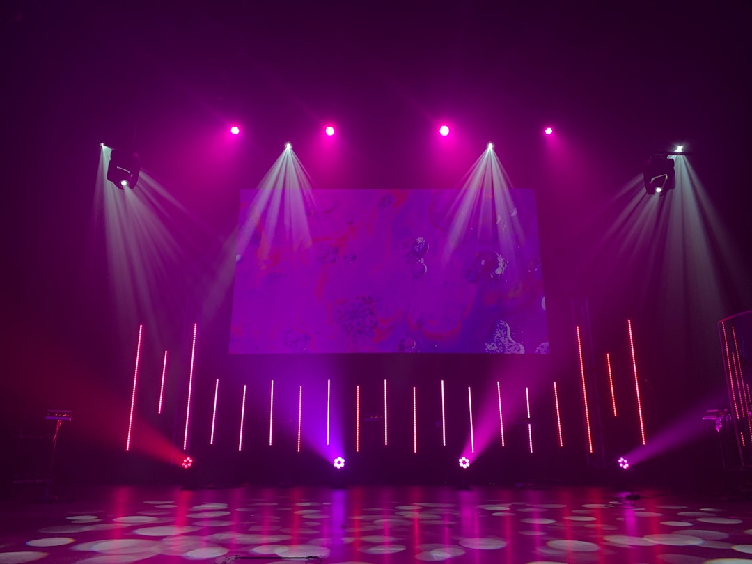 Stage lighting rig with moving heads and colored washes on an empty stage