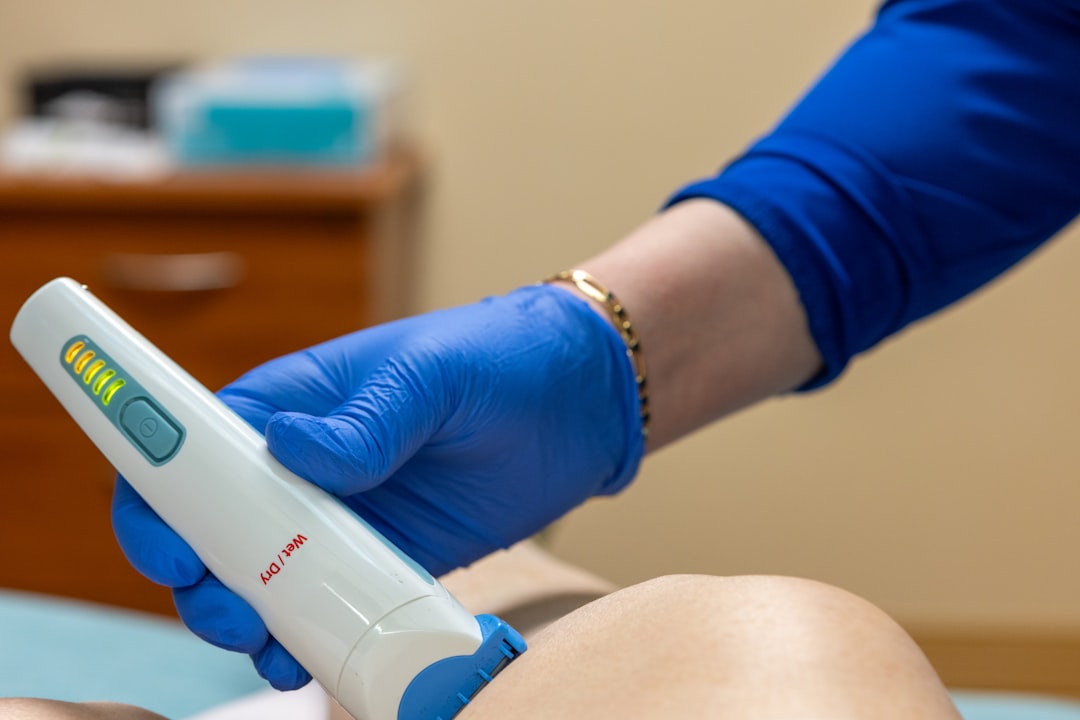 Medical professional using laser hair removal device on patient
