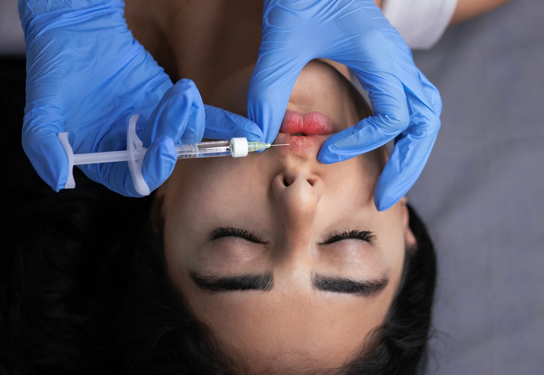 Professional administering dermal filler injection for volume restoration