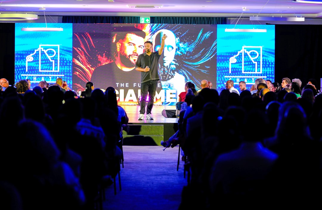 Speaker presenting on stage at corporate event with LED display