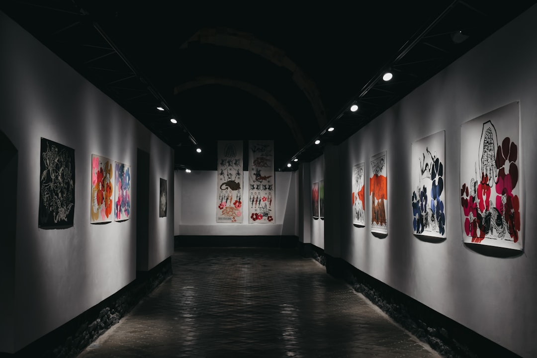 Gallery hallway with paintings and exhibition lighting