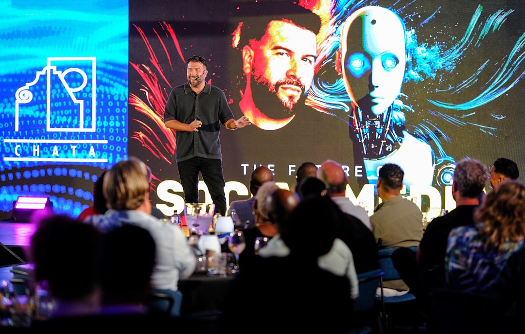 Presenter on stage with robot graphic on large LED video wall at tech conference
