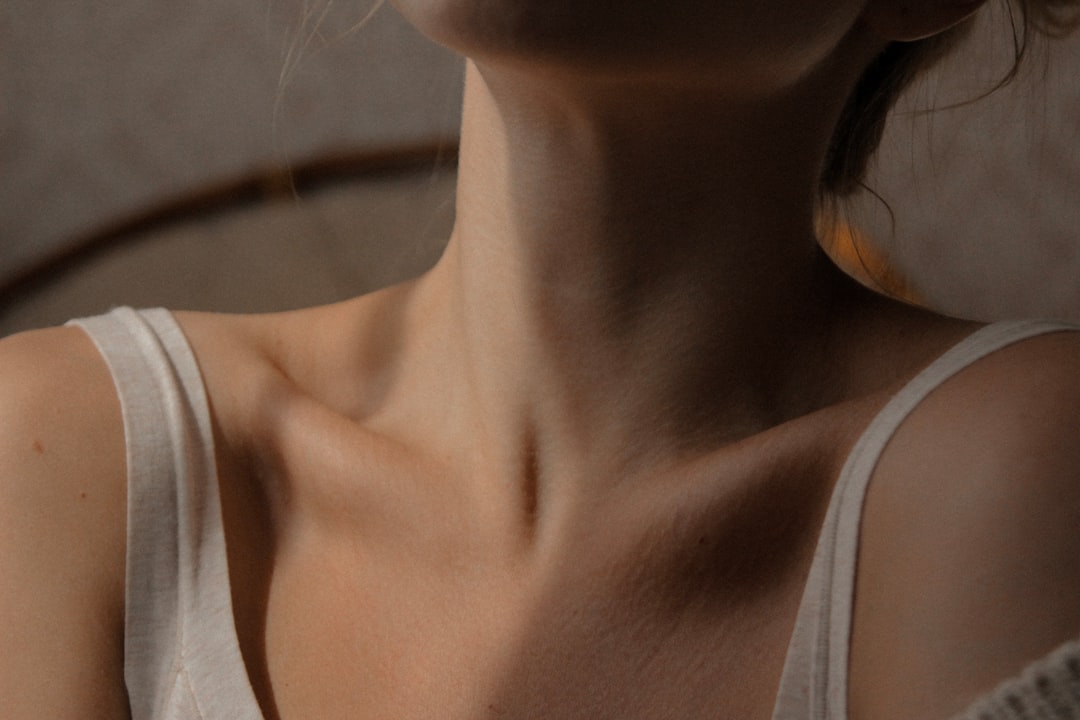 Woman applying anti-aging serum to neck and décolleté