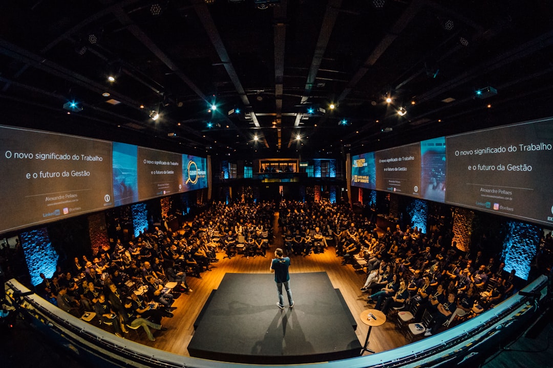 Speaker addressing a hybrid town hall audience on stage with camera setup
