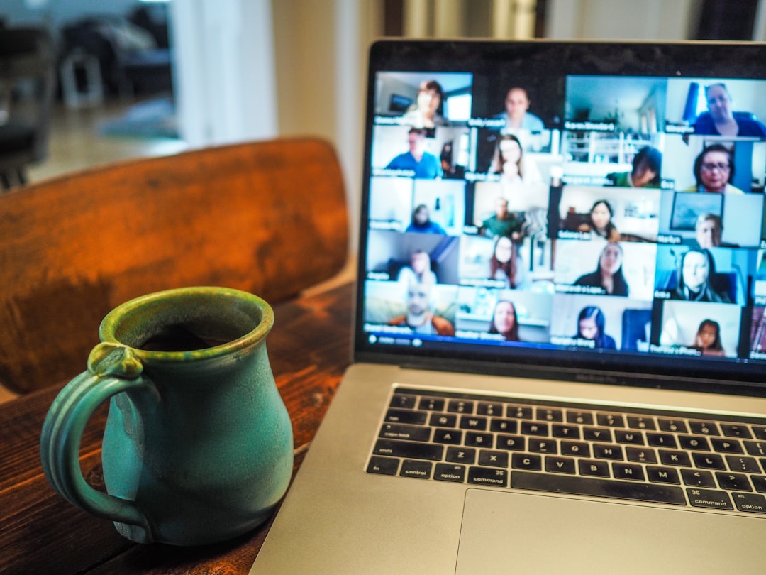 Laptop screen showing a Zoom Room video conference with remote participants for a hybrid town hall