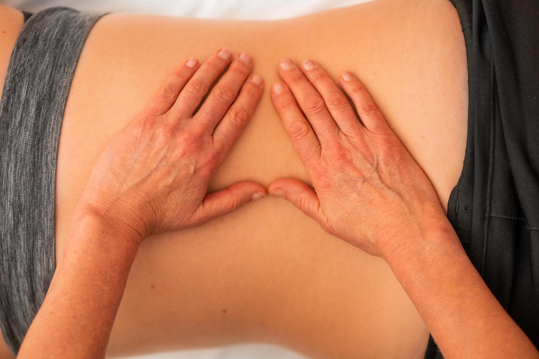 Therapist applying acupressure to a client's hand during marma point therapy
