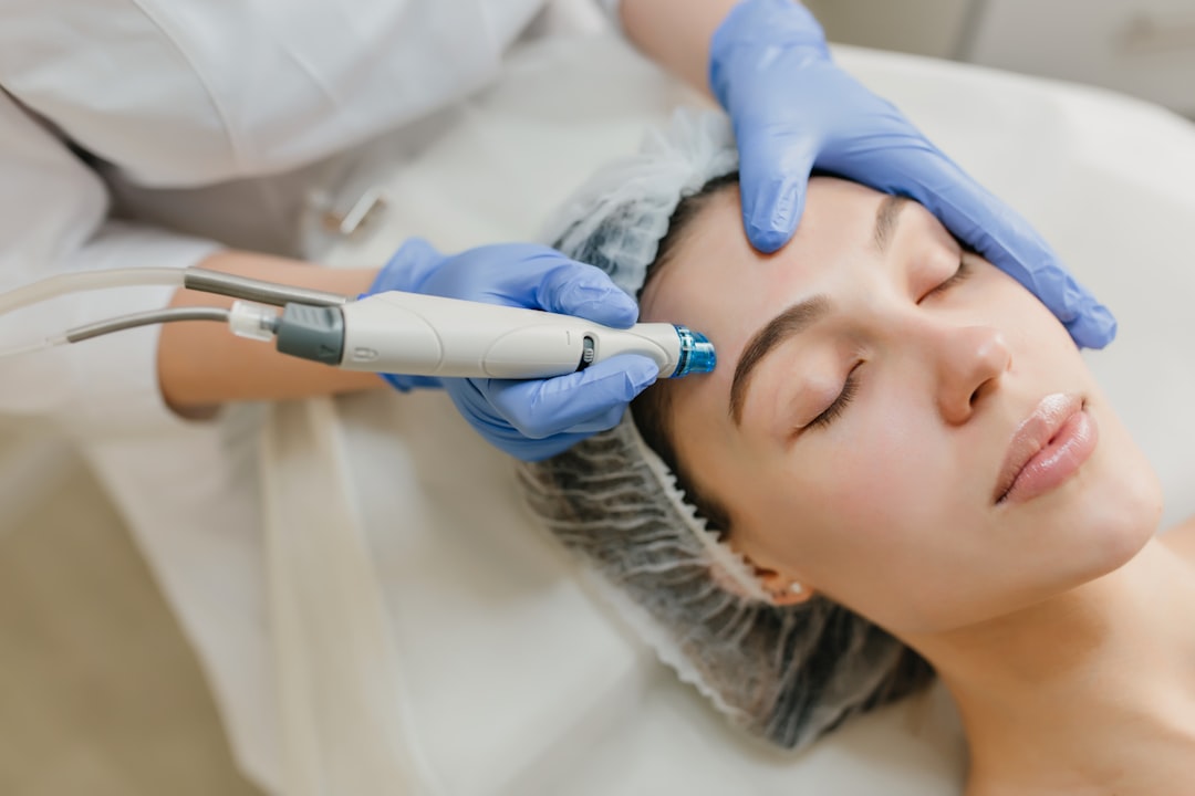 Esthetician performing radiofrequency skin tightening treatment on client's face
