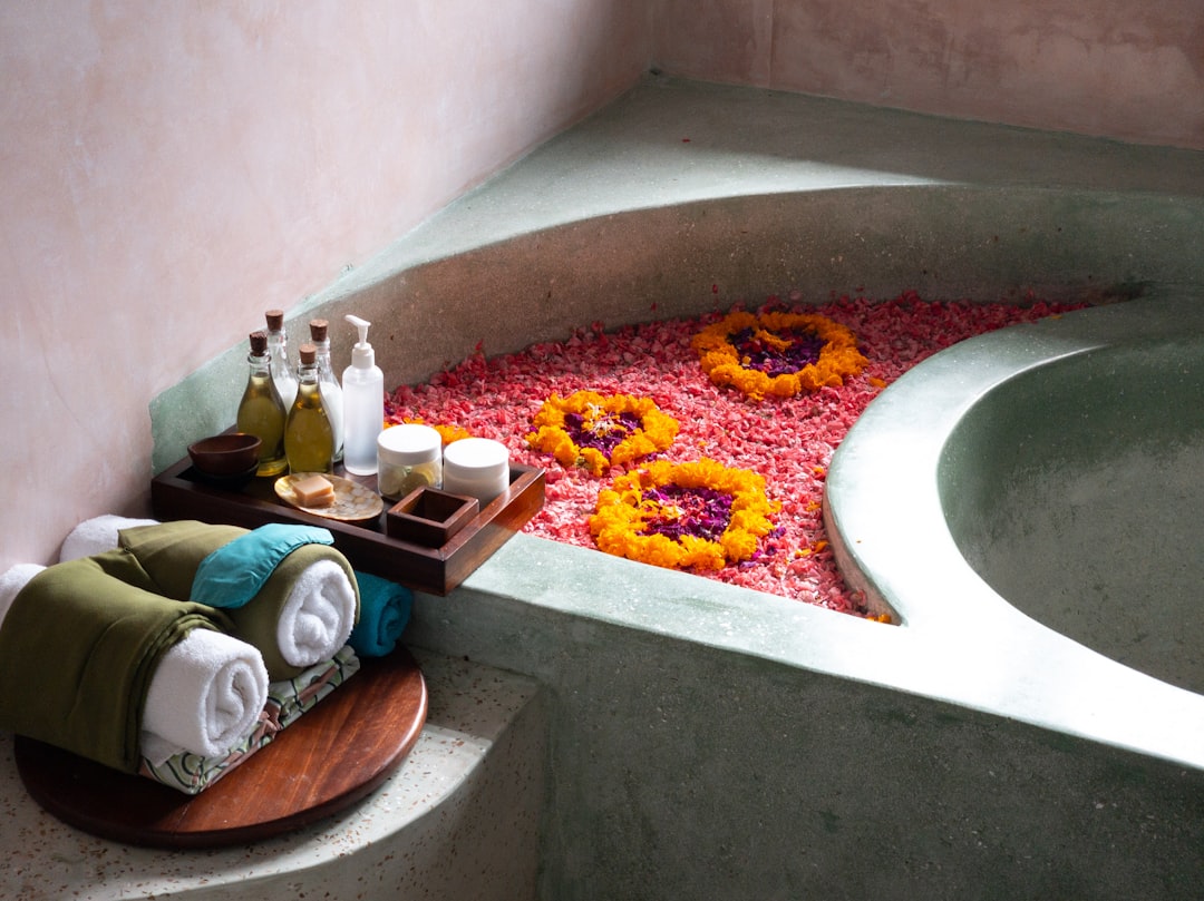 Ayurvedic bathing tray with flowers and herbal oils for authentic spa treatment