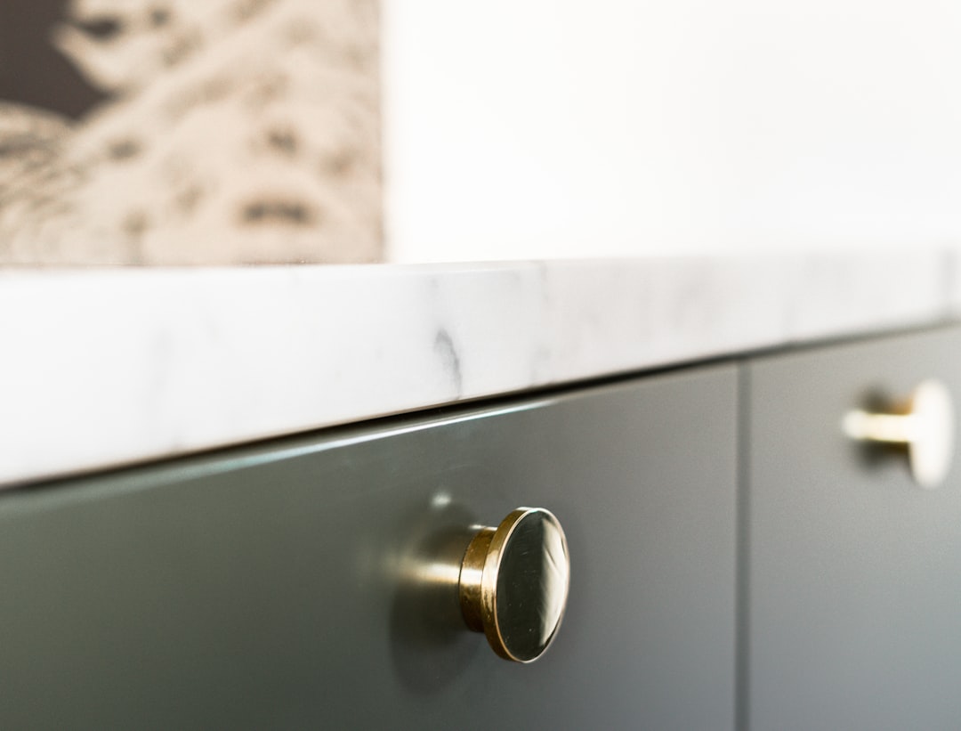 Gold cabinet knob on white cabinet door