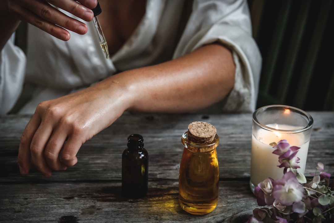 Applying a drop of organic facial oil from a glass dropper