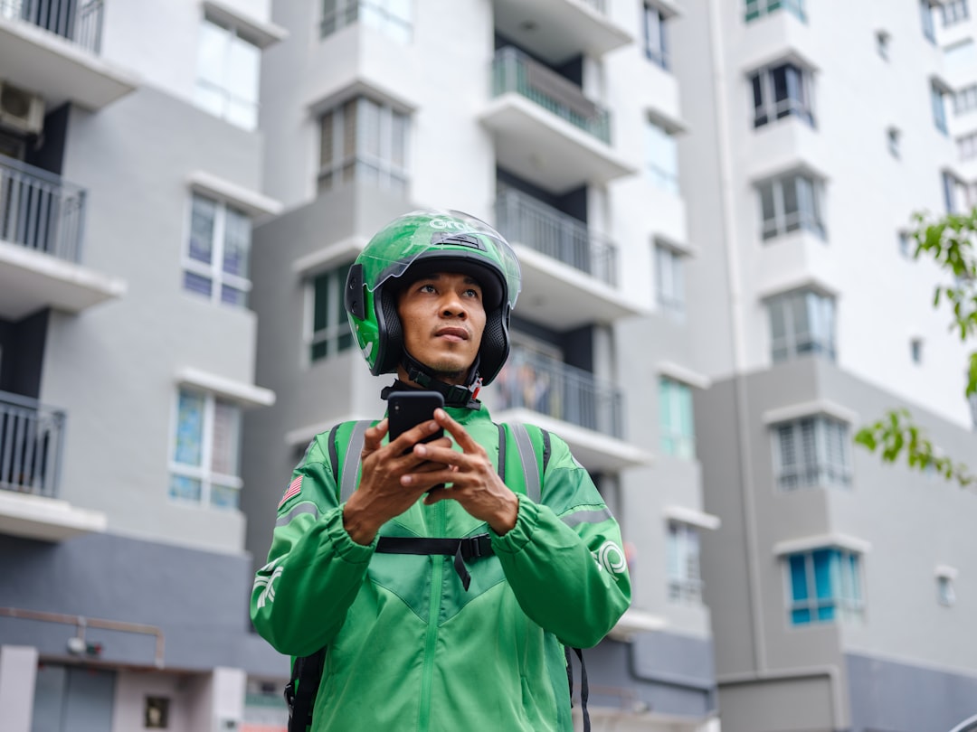 Delivery driver documenting delivery with a smartphone at a doorstep