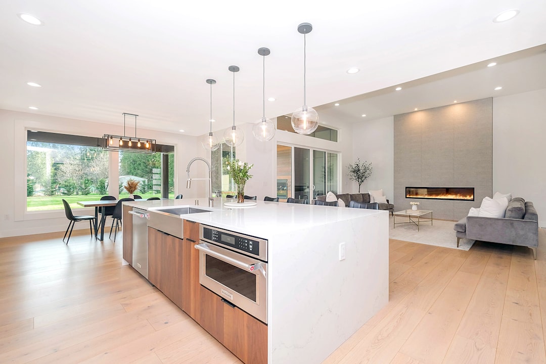 Warm hardwood flooring in a modern kitchen with white cabinets