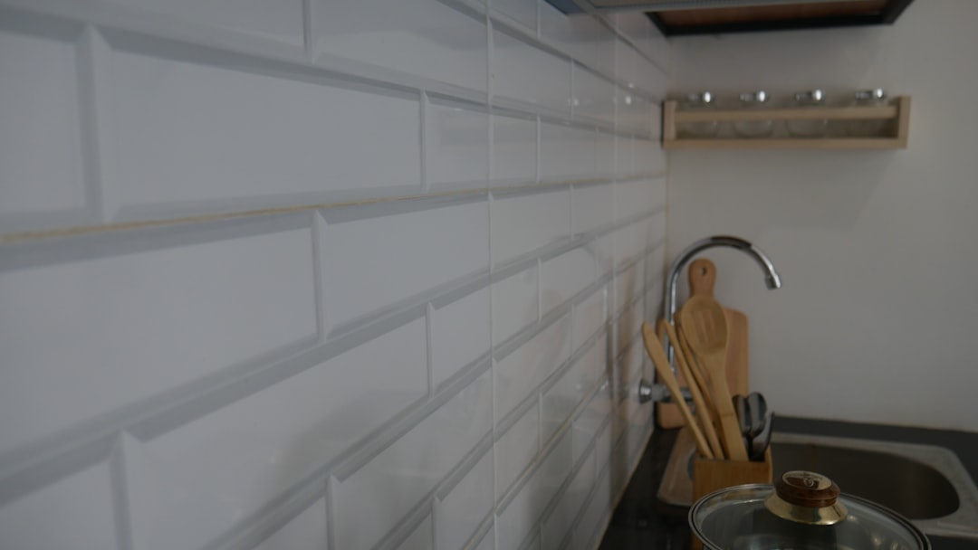 Close-up of white subway tile backsplash installation in kitchen