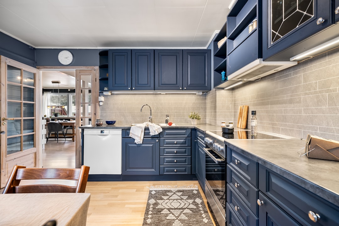 Dark blue kitchen cabinets paired with light tile backsplash